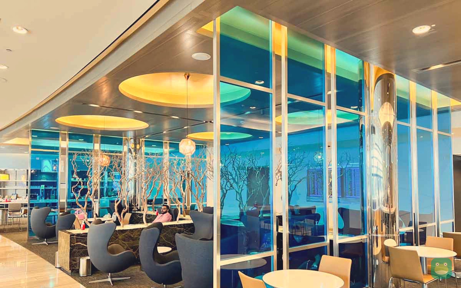 Seating by blue glass dividers with driftwood trees, United Club, Heathrow Terminal 2